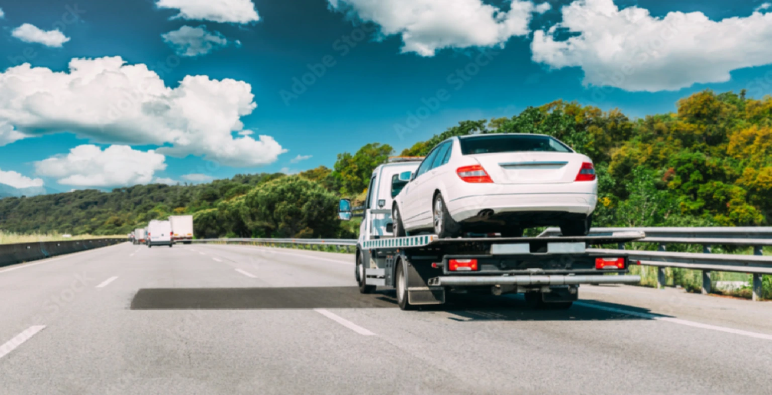 Junk car owner receiving a cash offer in Florida while a tow truck prepares for free pickup.